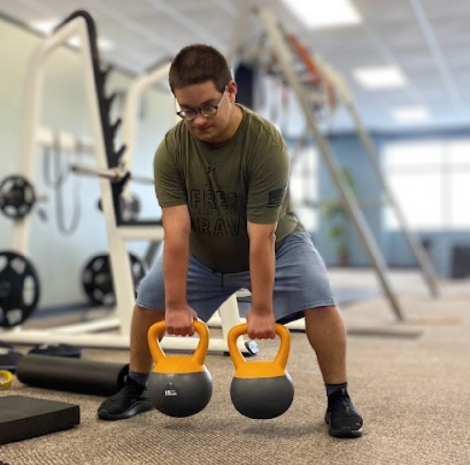 Inclusive Fitness Guy Lifting Yellow Kettlebells